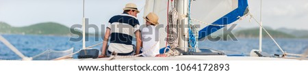 Back view of father and son family sailing on a luxury yacht or catamaran boat