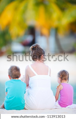 Back view of family sitting at beach