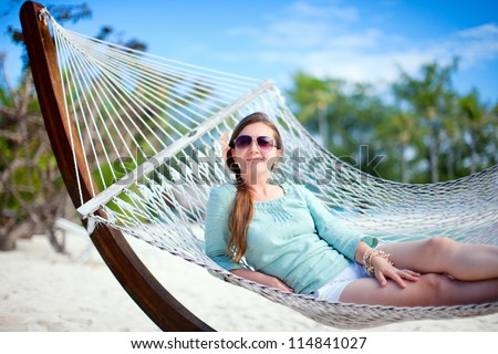 Beautiful woman relaxing at hammock on tropical beach