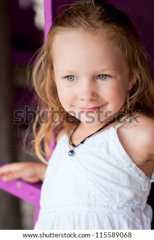 Charming little girl in white sundress and black pearl necklace
