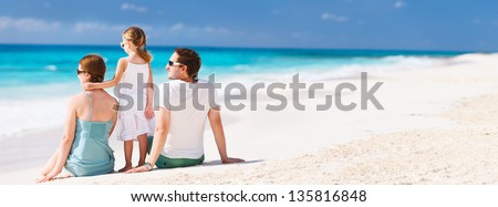 Back view of a family on a tropical beach