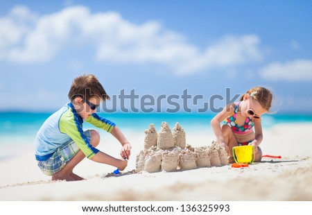 Brother And Sister Making Sand Castle At Tropical Beach