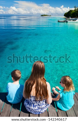 Back view of mother and kids enjoying ocean view