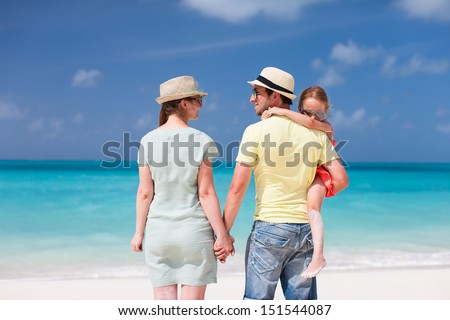 Back view of a happy family on tropical beach