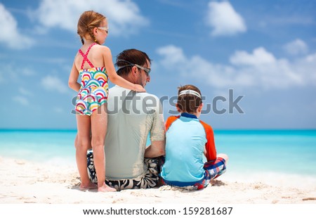 Back view of father and kids enjoying beach vacation