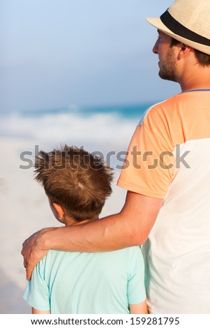 Back view of father and son at beach