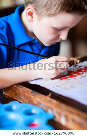 Cute little boy painting a batik