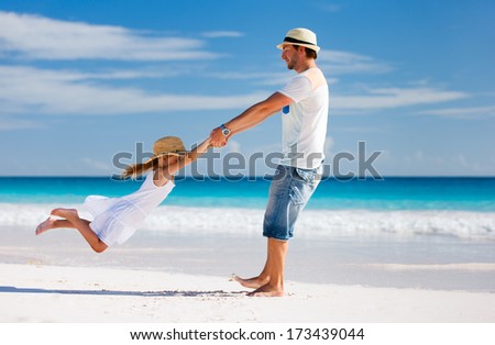 Happy father and his adorable little daughter at tropical beach having fun Happy father and his adorable little daughter at tropical beach having fun