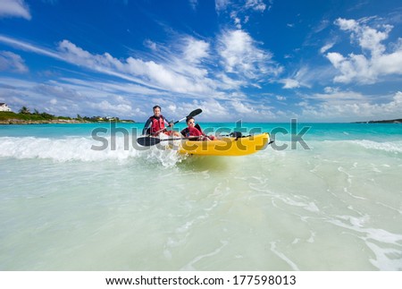 Father and son kayaking at tropical ocean