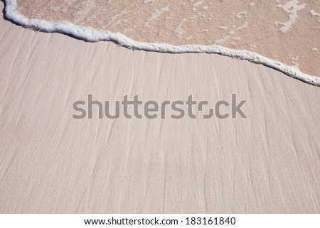Background of a tropical pink sand with a ocean wave