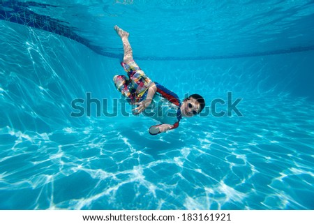 Portrait of a cute little boy swimming underwater