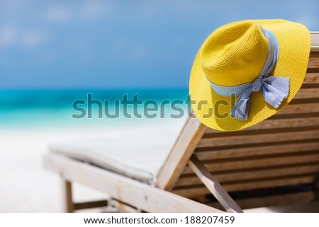 Yellow hat on a lounge chair at tropical beach