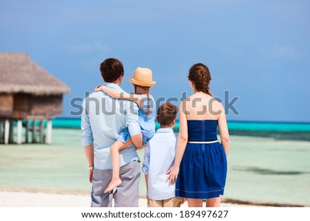 Back view of a beautiful family on a beach during summer vacation