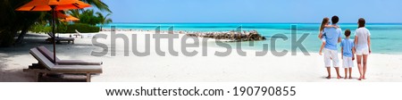Back view of a beautiful family on a beach during summer vacation Wide panorama perfect for banners Back view of a beautiful family on a beach during summer vacation Wide panorama perfect for banners
