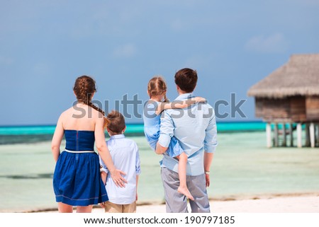 Back view of a beautiful family on a beach during summer vacation