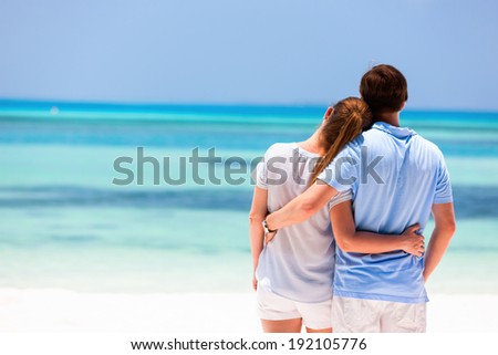 Back view of a couple on a tropical beach vacation