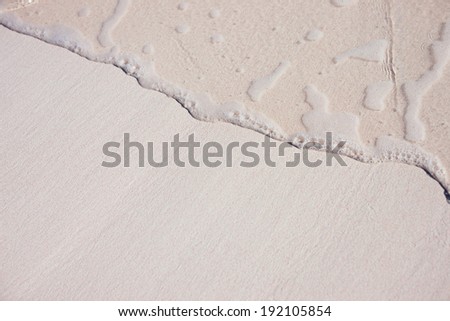 Background of a tropical pink sand with an ocean wave
