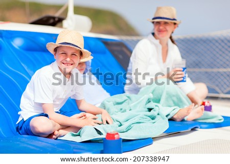 Mother and her kids relaxing having great time sailing at luxury yacht or catamaran boat