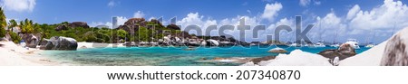 Panorama of a picture perfect beach with white sand, unique huge granite boulders, turquoise ocean water and blue sky at Virgin Gorda, British Virgin Islands in Caribbean