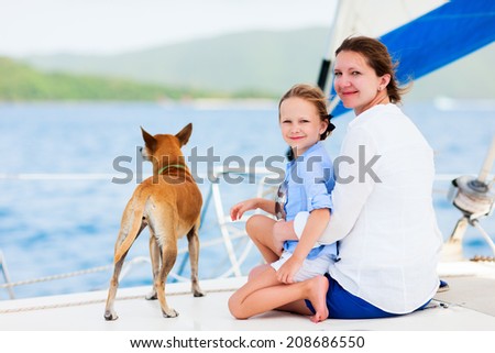 Mother, daughter and their pet dog sailing on a luxury yacht or catamaran boat