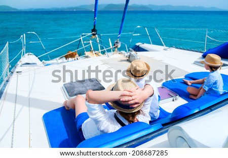 Back view of mother and her kids relaxing having great time sailing at luxury yacht or catamaran boat
