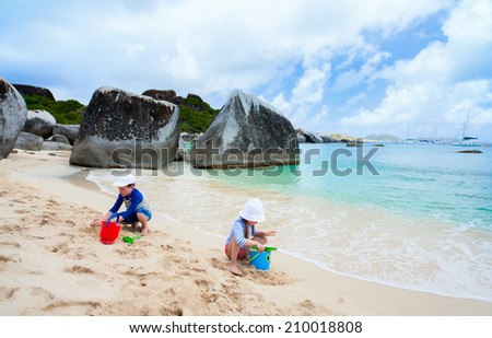 Kids wearing sun protection rash guard at beach during summer vacation