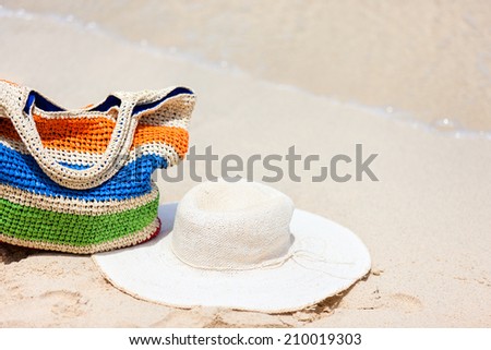 Straw hat and bag on a tropical beach with white sand on exotic Caribbean island