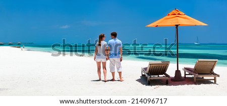 Back view of a couple on a tropical beach vacation panorama perfect for banners