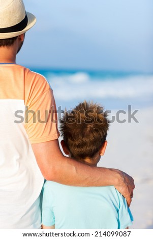 Back view of father and son on summer vacation at beach