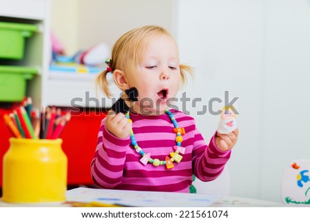 Adorable toddler girl playing with finger puppets at home or daycare