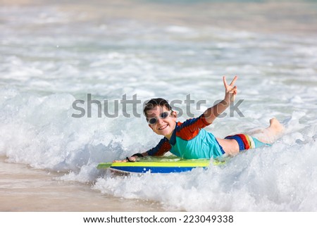 Little boy on vacation having fun swimming on boogie board