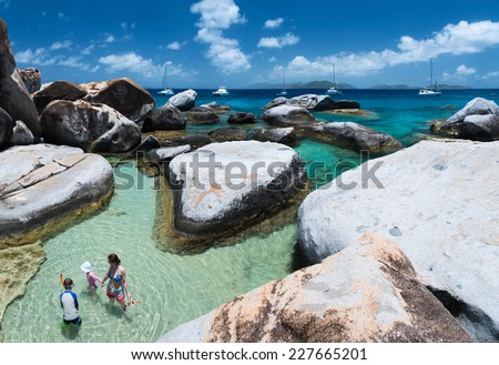 Family of mother and kids at The Baths beach area major tourist attraction at Virgin Gorda, British Virgin Islands, Caribbean