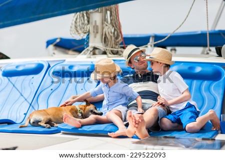 Father, kids and their pet dog sailing on a luxury yacht or catamaran boat