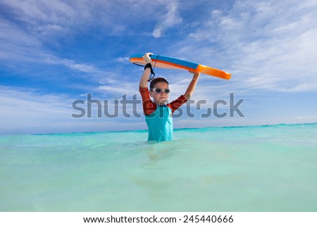 Little boy on vacation having fun surfing on boogie board