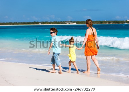 Mother and kids on a Caribbean vacation walking along a beach