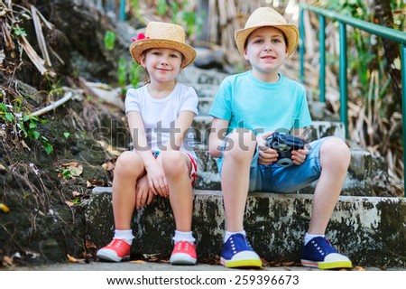 Brother and sister outdoor in a park or forest on summer day