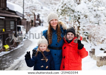 Family of mother and kids at old district of historical Takayama town in Japan on winter day