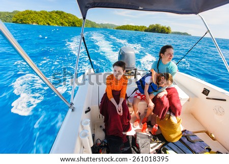 Family of mother and her kids at small boat on private water tour or excursion
