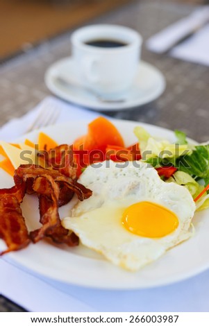 Delicious breakfast with fried eggs, bacon and vegetables