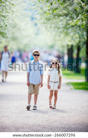 Kids brother and sister outdoors in a beautiful park at spring day
