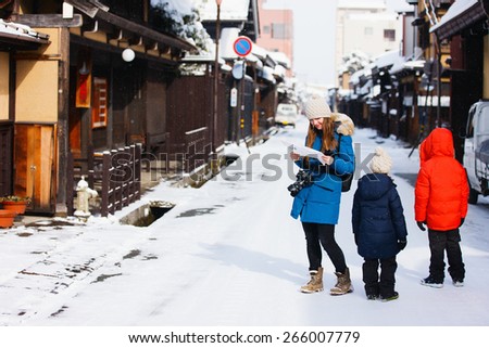 Family of mother and kids at old district of historical Takayama town in Japan on winter day