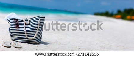 Bag, sun glasses and flip flops on a tropical beach. Wide panorama, perfect for banners