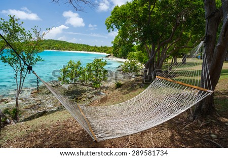 Beautiful tropical beach with white sand, hammock, turquoise ocean water and blue sky at St John, US Virgin Islands in Caribbean
