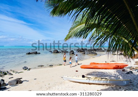 Mother and kids family at tropical beach on Rarotonga island, Cook Islands, South Pacific