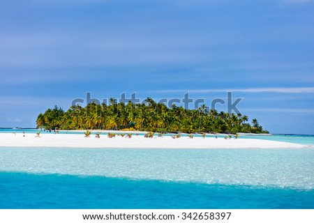 Stunning tropical Aitutaki One Foot island with palm trees, white sand, turquoise ocean water and blue sky at Cook Islands, South Pacific