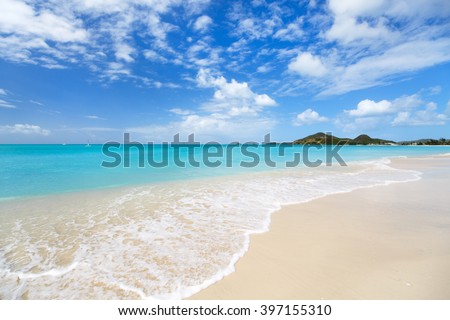 Idyllic tropical beach with white sand, turquoise ocean water and blue sky at Antigua island in Caribbean