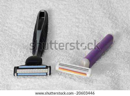 Man\'s and woman\'s disposable razors laying on a white towel