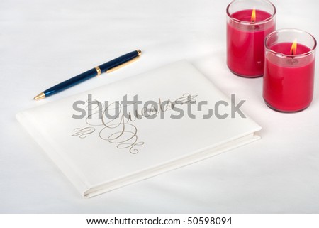 Wedding guest book with pen and candles on a white background
