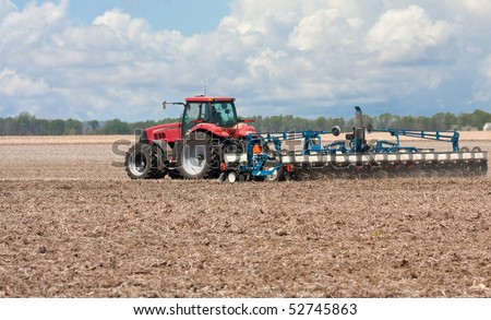 Farm tractor planting corn in a field