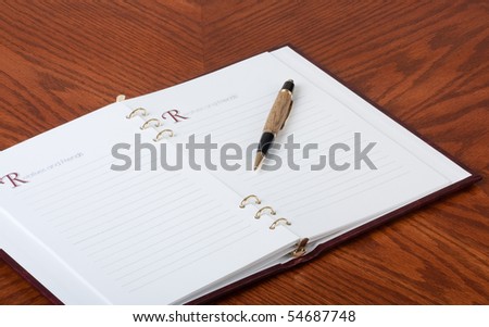 Opened guest book with a pen on a wood table